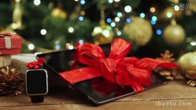 平板电脑，智能手机和智能手表与礼物和<strong>装饰品</strong>在圣诞树前与灯在木桌